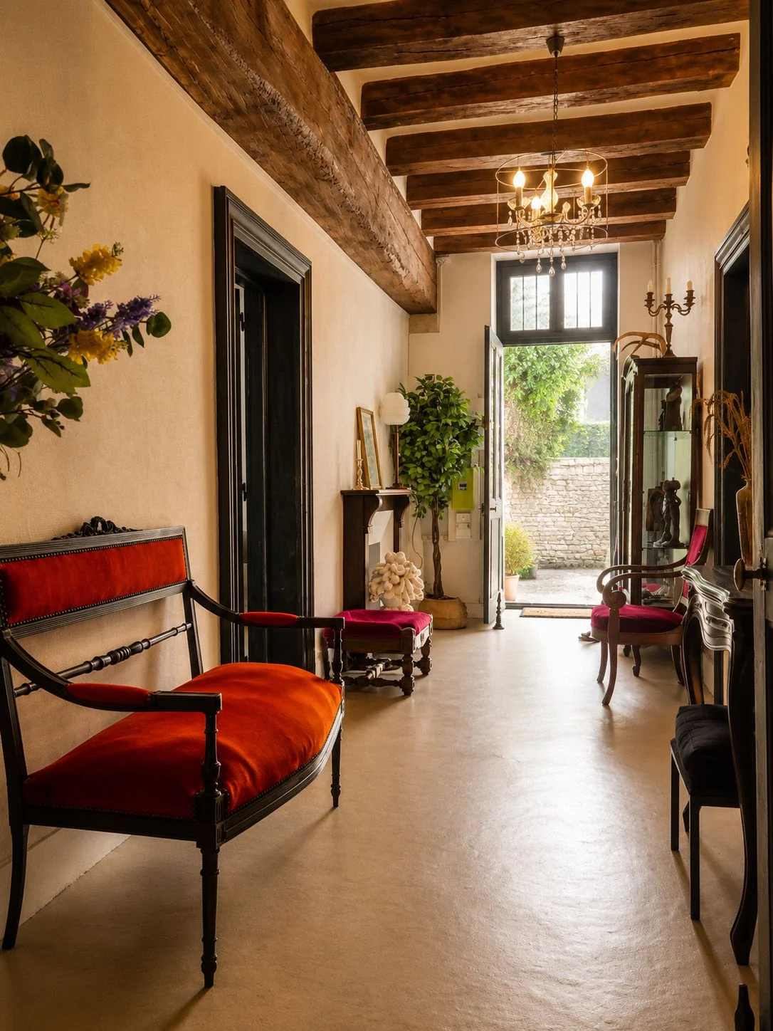 Le corridor, ses poutres anciennes et ses fauteuils rouges.